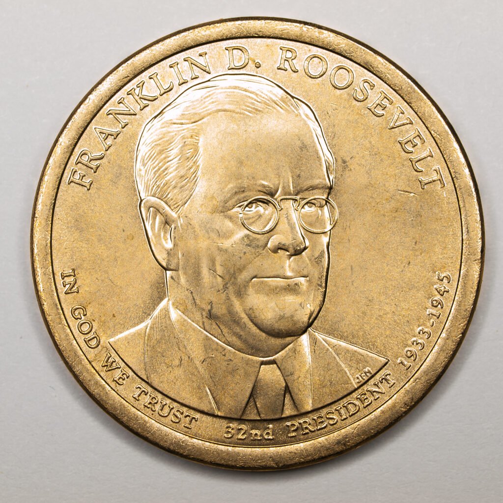 A gold coin engraved with the image of a confident, bespectacled Franklin D. Roosevelt.