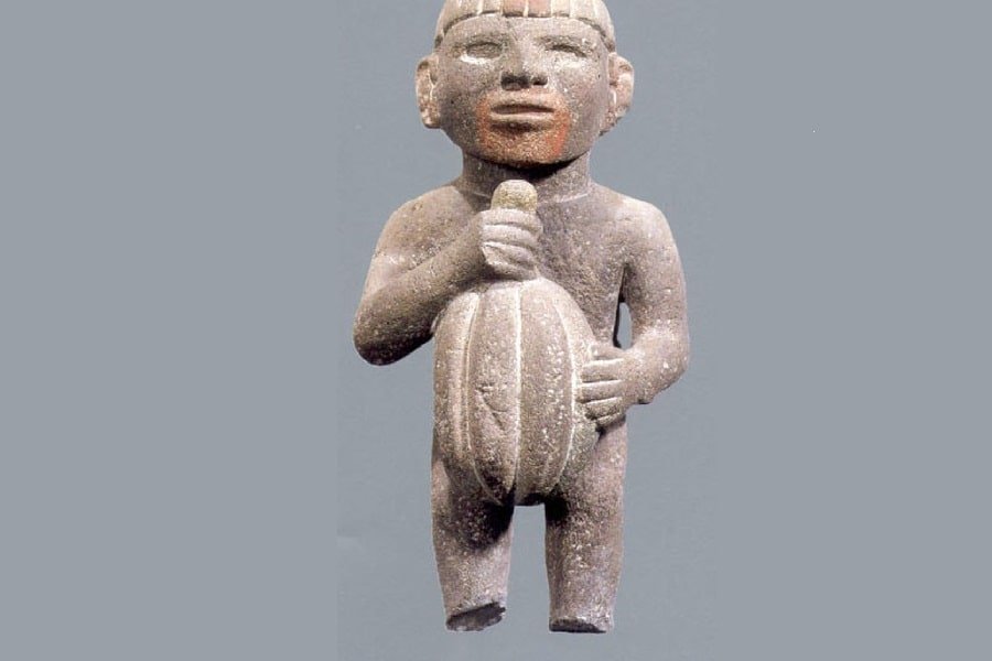 a-sculpture-of-an-aztec-man-holding-cacao-fruit