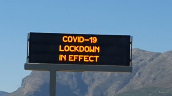A picture of an electronic roadsign, located in the Western Cape of South Africa, reading "COVID-19 lockdown in effect".