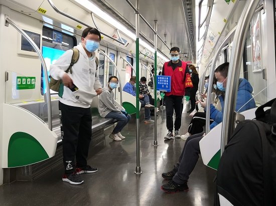 A picture of the interior of a Wuhan Metro train. Various passengers can be seen wearing protective face masks.
